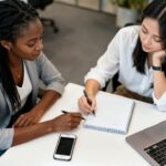 women, office, job, team, portable, notebook, writing, business, professional, sitting, white, gray, black, study, meeting, creativity, success, career, friendship, co-working, technology, generated by ai